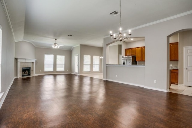 unfurnished living room with ceiling fan with notable chandelier, a fireplace, crown molding, and light hardwood / wood-style flooring