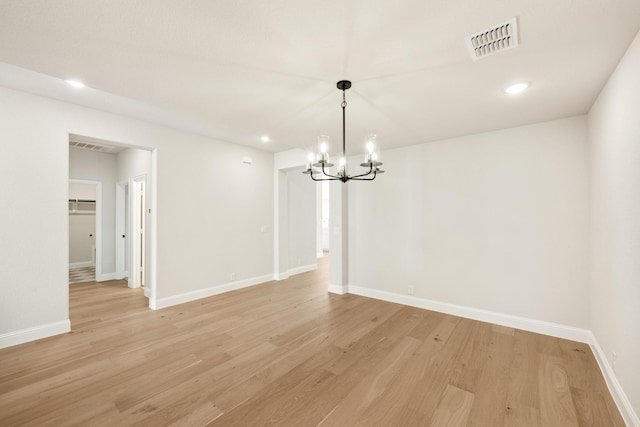 unfurnished dining area with light hardwood / wood-style floors and an inviting chandelier