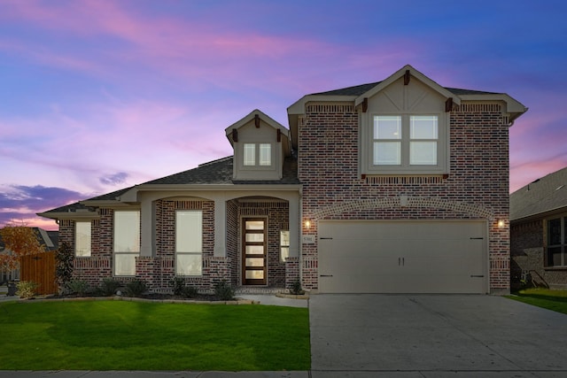 view of front of house with a garage and a yard