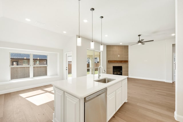 kitchen with stainless steel dishwasher, a kitchen island with sink, a healthy amount of sunlight, and sink