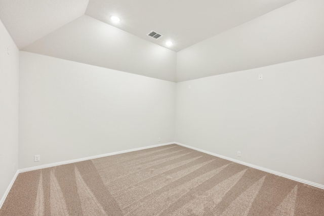 spare room with carpet floors and vaulted ceiling