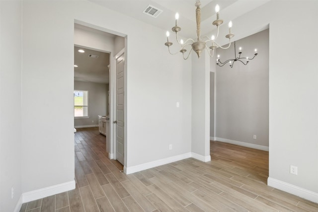 unfurnished dining area with an inviting chandelier