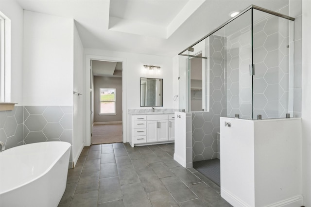 bathroom featuring vanity, separate shower and tub, tile walls, and tile patterned floors