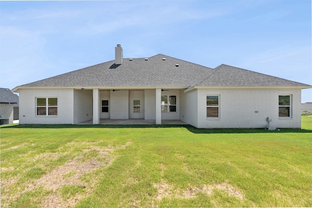 rear view of house featuring a patio and a yard