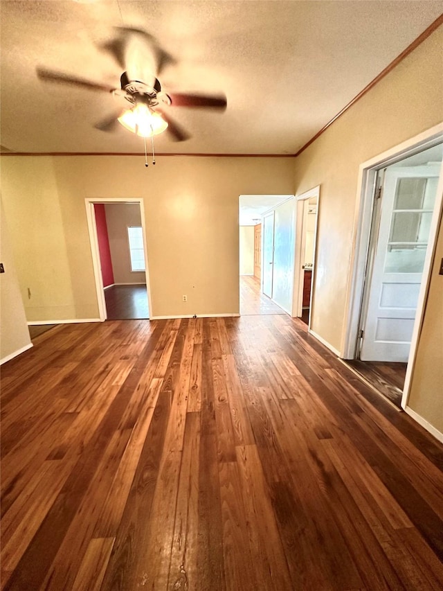 empty room featuring crown molding, ceiling fan, dark hardwood / wood-style flooring, and a textured ceiling