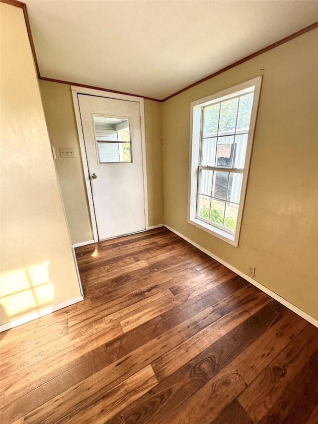 unfurnished room featuring crown molding and hardwood / wood-style flooring