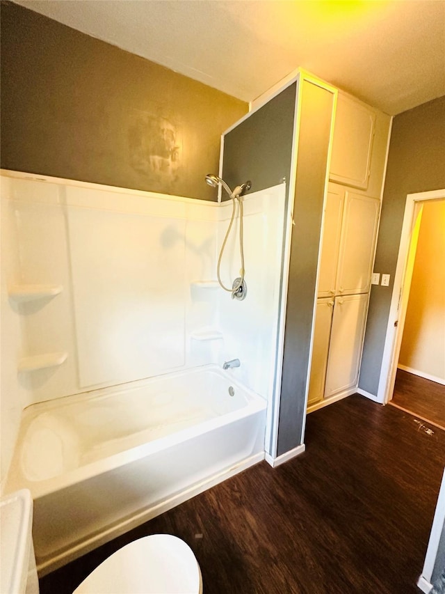 bathroom with toilet, hardwood / wood-style floors, and  shower combination