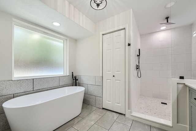 bathroom featuring vanity, tile walls, tile patterned floors, and separate shower and tub