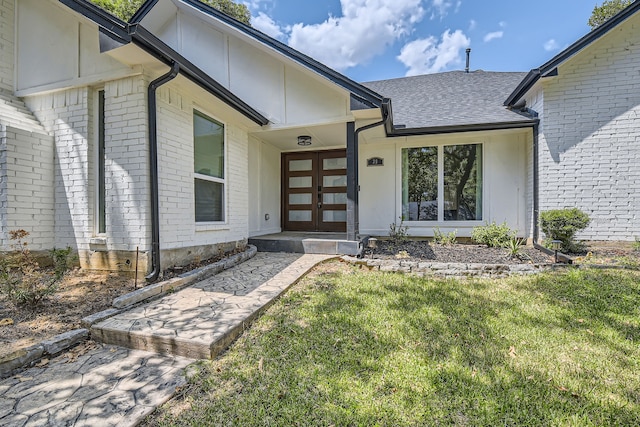 view of exterior entry featuring a lawn