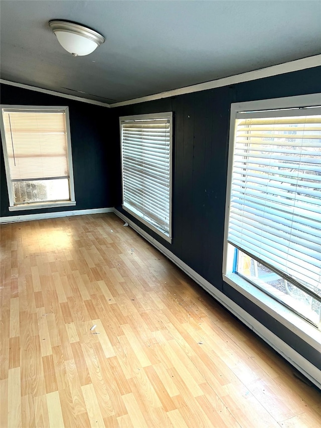 unfurnished room featuring light wood-type flooring and crown molding