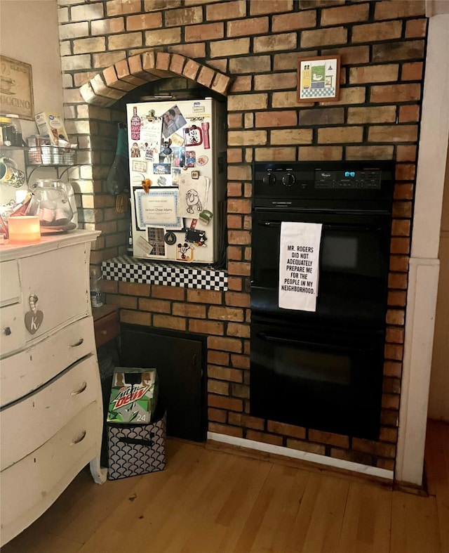 interior details featuring double oven and hardwood / wood-style floors