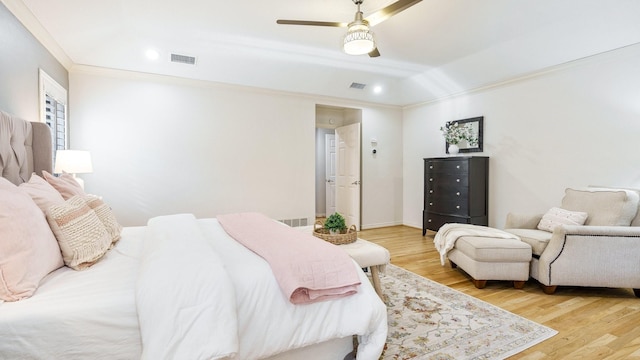 bedroom with light hardwood / wood-style flooring, ornamental molding, ceiling fan, and vaulted ceiling