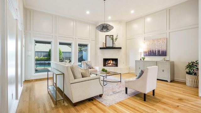 living room with a large fireplace and light wood-type flooring