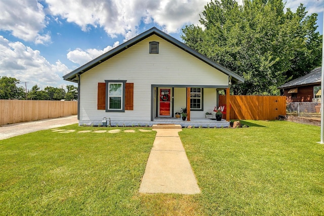 bungalow-style home with covered porch and a front yard