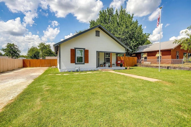 rear view of property featuring covered porch and a yard