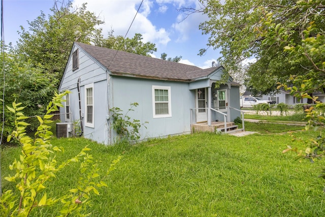 back of house featuring a lawn and central AC