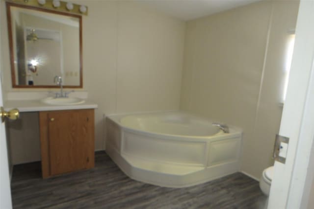 bathroom featuring toilet, a bathtub, wood-type flooring, and vanity