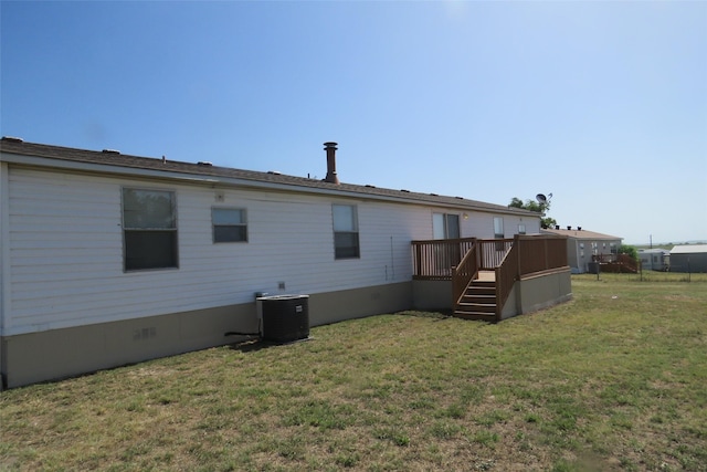 back of house featuring central AC, a wooden deck, and a yard