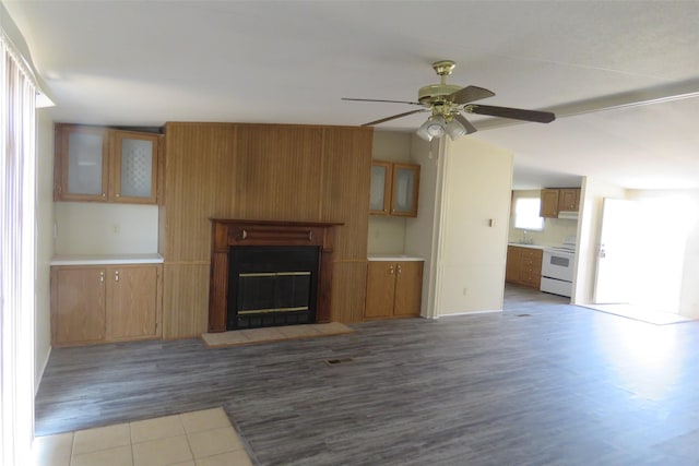 unfurnished living room featuring lofted ceiling, ceiling fan, sink, and hardwood / wood-style flooring