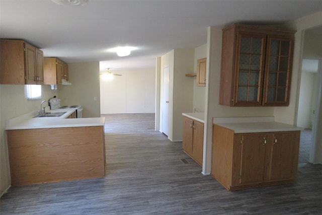 kitchen with kitchen peninsula, ceiling fan, dark wood-type flooring, white electric range, and sink