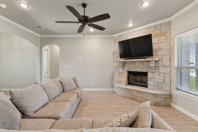 interior details with a stone fireplace, wood-type flooring, and ornamental molding