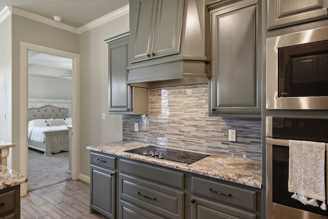 kitchen with stainless steel appliances, light stone countertops, custom exhaust hood, decorative backsplash, and light carpet