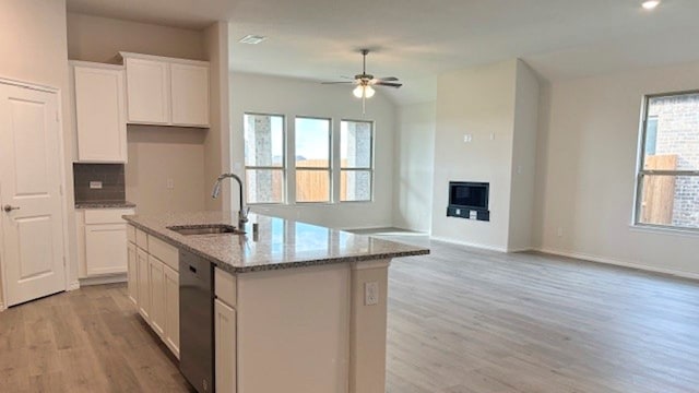 kitchen with ceiling fan, sink, a kitchen island with sink, and a healthy amount of sunlight