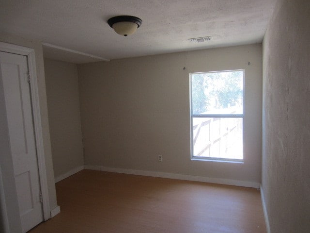 spare room featuring a wealth of natural light and hardwood / wood-style flooring