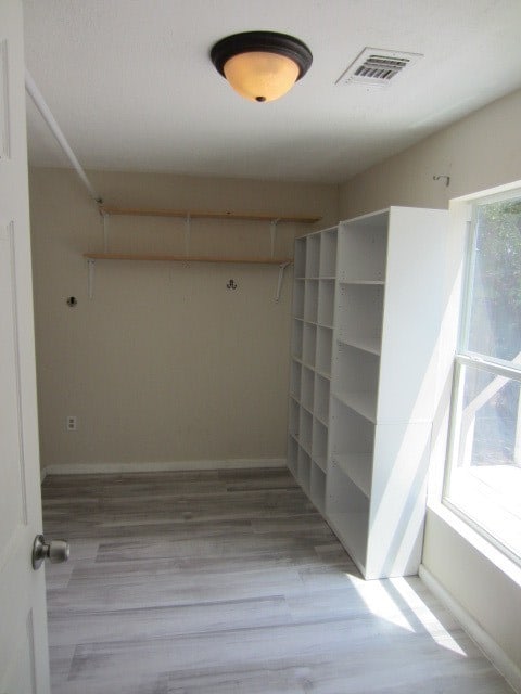 walk in closet with hardwood / wood-style floors