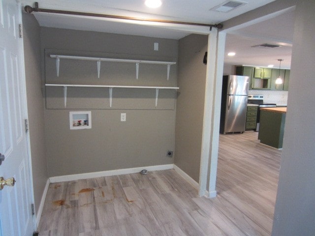 clothes washing area with washer hookup and light wood-type flooring