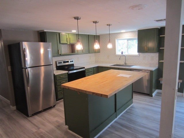 kitchen featuring light wood-type flooring, wooden counters, sink, and stainless steel appliances