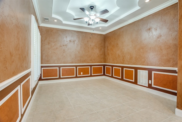 empty room with ceiling fan, ornamental molding, light tile patterned floors, and a tray ceiling