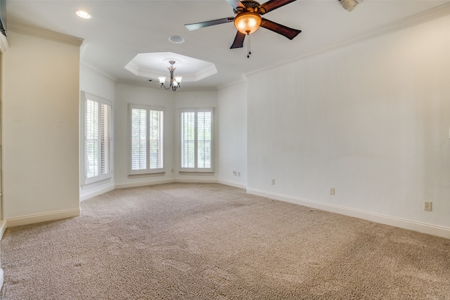 spare room featuring ornamental molding, carpet floors, ceiling fan with notable chandelier, and a tray ceiling