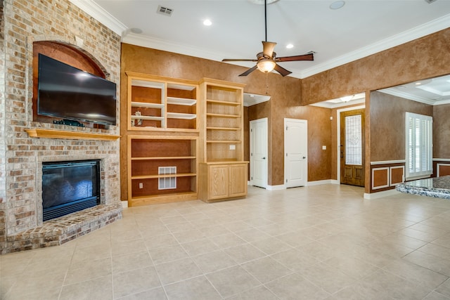 unfurnished living room featuring a brick fireplace, ornamental molding, light tile patterned floors, and ceiling fan