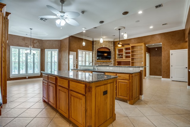 kitchen featuring ceiling fan with notable chandelier, decorative light fixtures, and a kitchen island