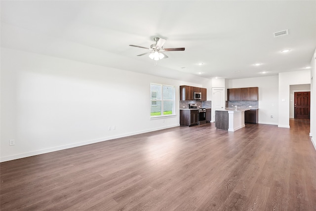 unfurnished living room featuring ceiling fan, sink, and dark hardwood / wood-style floors