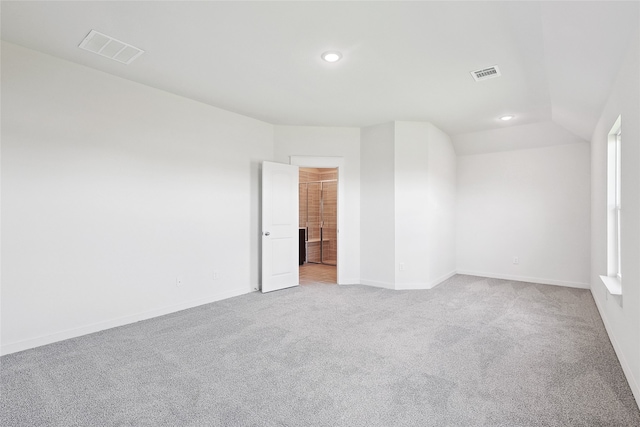 carpeted spare room with lofted ceiling