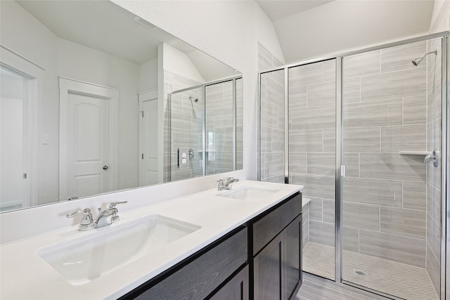 bathroom with vanity, lofted ceiling, walk in shower, and wood-type flooring