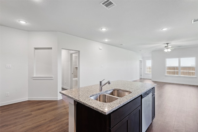 kitchen featuring a center island with sink, light stone counters, dishwasher, dark wood-type flooring, and sink