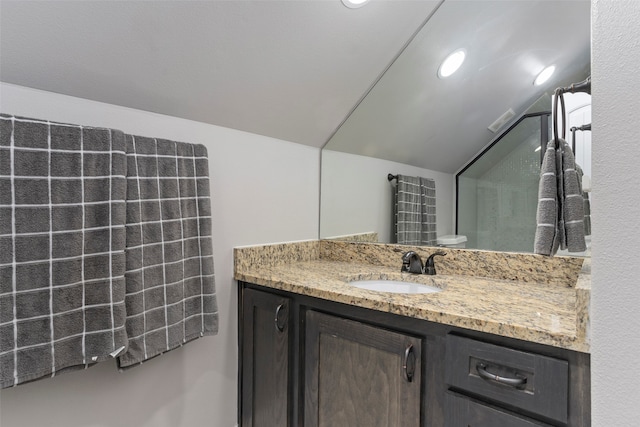 bathroom with lofted ceiling, vanity, and toilet