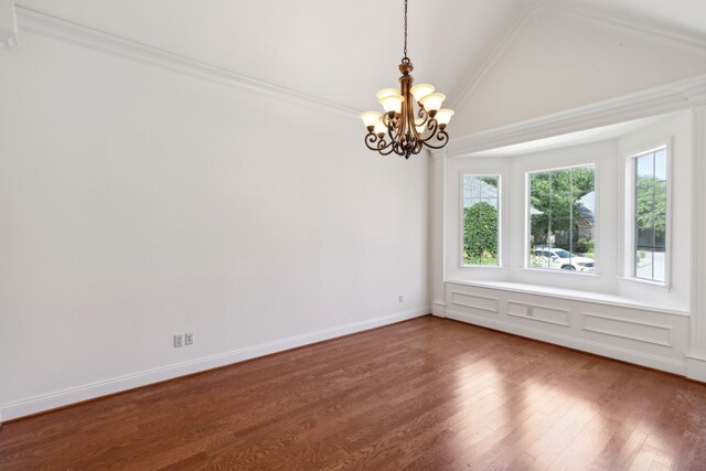 empty room featuring an inviting chandelier, lofted ceiling, and wood-type flooring