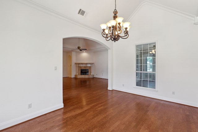 unfurnished living room featuring vaulted ceiling, ornamental molding, dark hardwood / wood-style flooring, a fireplace, and ceiling fan with notable chandelier