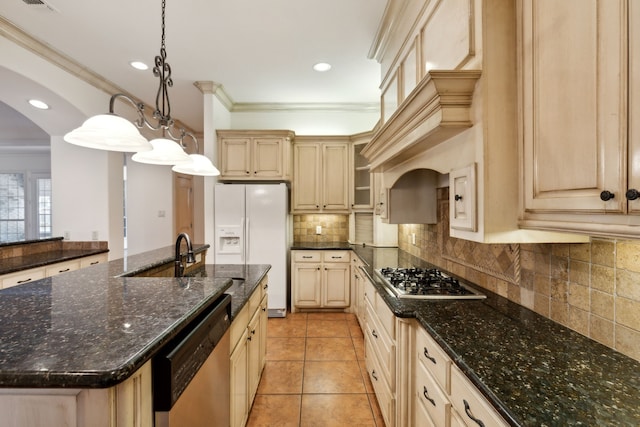 kitchen featuring appliances with stainless steel finishes, decorative light fixtures, a kitchen island with sink, and dark stone counters