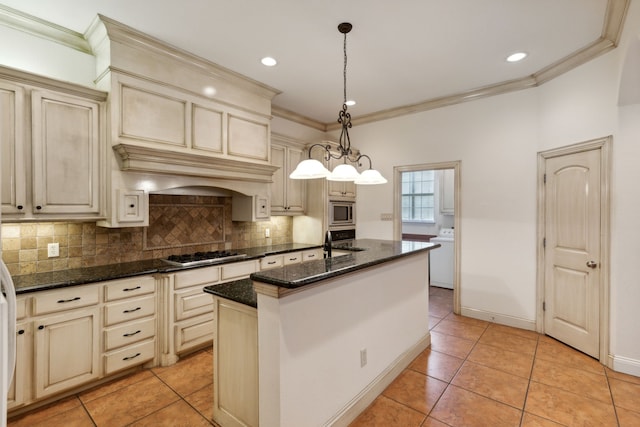 kitchen featuring decorative light fixtures, a kitchen island with sink, and cream cabinetry