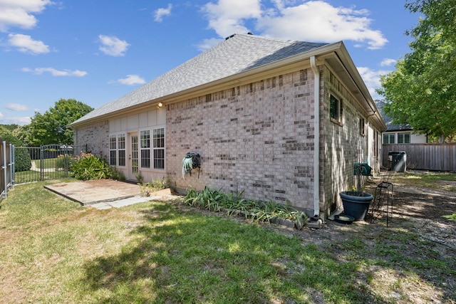 back of house featuring a lawn and a patio area