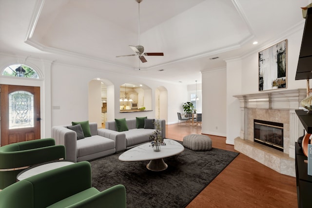 living room with ornamental molding, plenty of natural light, hardwood / wood-style floors, and a tray ceiling