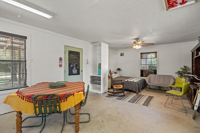 dining space with ceiling fan and crown molding