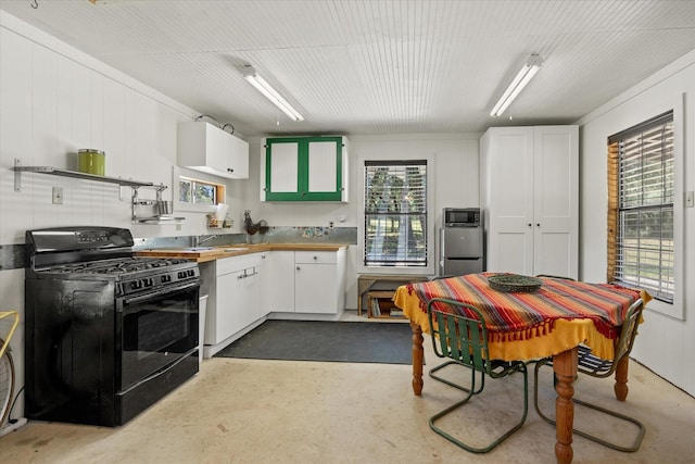 kitchen with black gas range, a wealth of natural light, and white cabinets