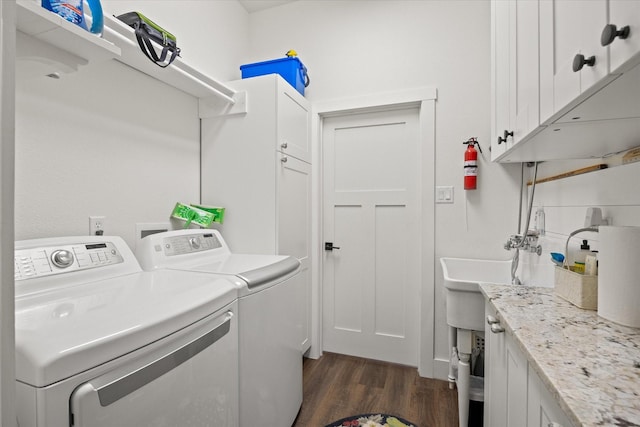 laundry area with dark hardwood / wood-style floors, cabinets, independent washer and dryer, and sink