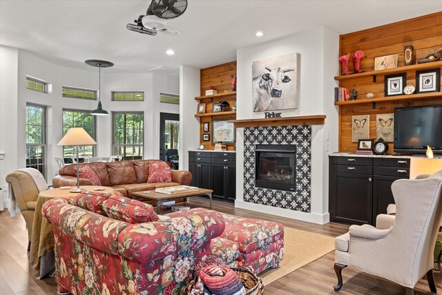 living room with a tile fireplace and light hardwood / wood-style flooring